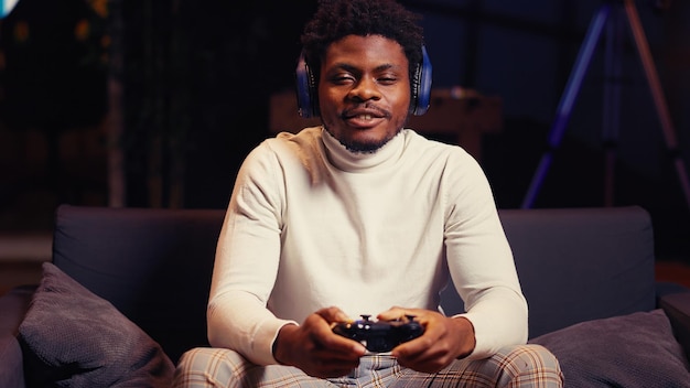 Man having online gaming session with friends talking with them through headphones microphone