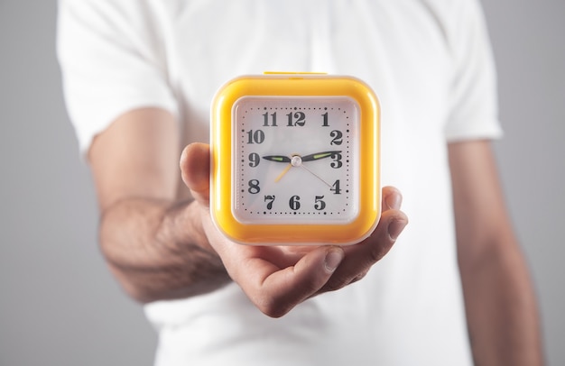 Man holding yellow clock