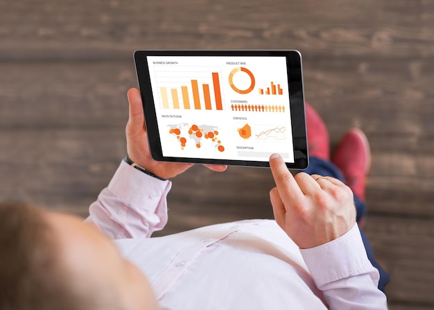 man looking at sales data on tablet