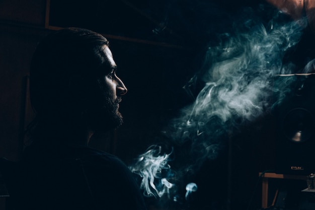 man looking at smoke in darkroom