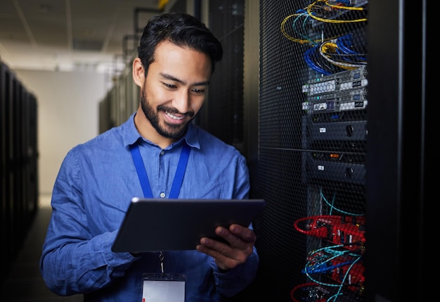 Man tablet and server room programming or coding for cybersecurity information technology and data protection backup Happy engineering person on digital software and hardware solution in basement