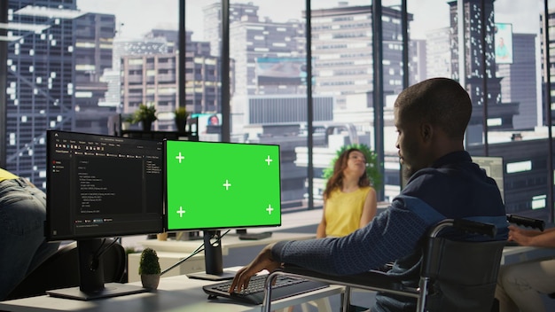Man with paraplegia optimizing company software with mockup computer
