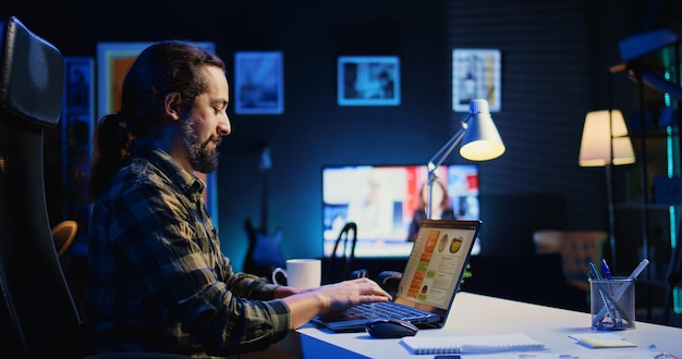 Man working in personal office checking statistical data financial graphs