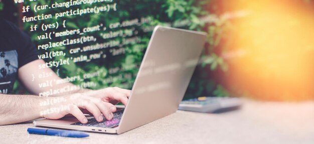 Man working on laptop in garden Closeup of male hands typing on computer