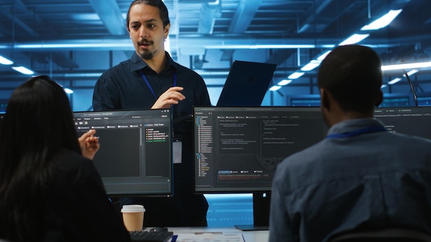 Manager and IT support specialists working together supervising server rows