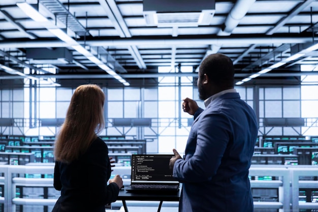 Manager overseeing data center next to employee doing inspection