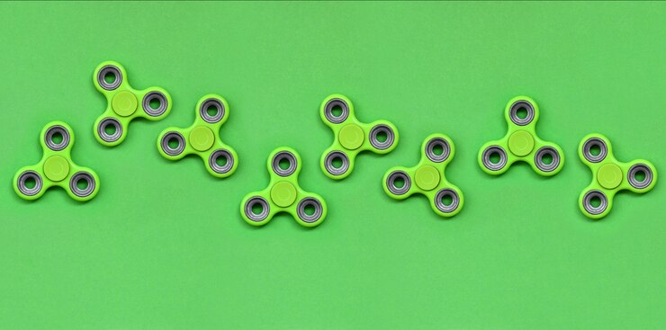 Bild many green fidget spinners lies on texture background