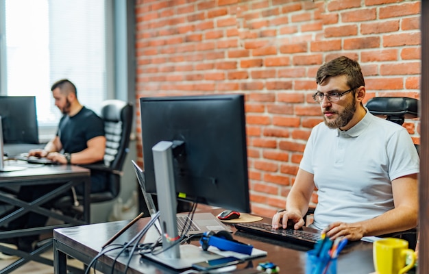 Men working in the office. Young business man sitting in office and working on desktop