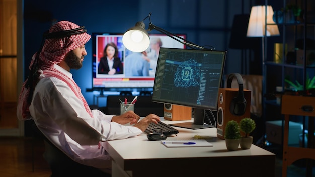 Middle Eastern system administrator programming AI used for machine learning training Programmer working from home running code on computer updating artificial intelligence neural networks