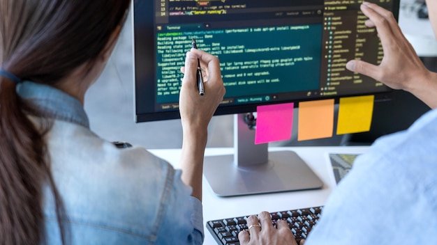 Midsection of programmers working on table