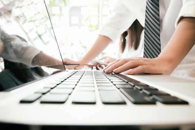 Midsection of woman using laptop in office