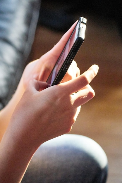 midsection of woman using smart phone at home