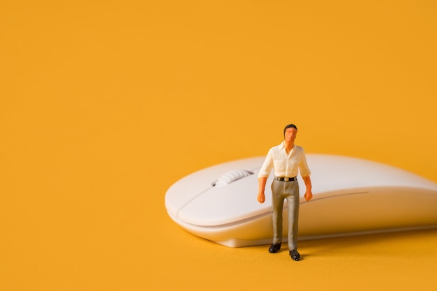 Miniature people on a yellow background a male programmer or businessman