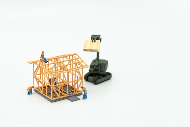 Miniatyrfolk Byggnadsarbetare reparerar En modellhusmodell