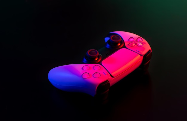 Modern white gamepad illuminated red and blue on a dark background game controller for video games