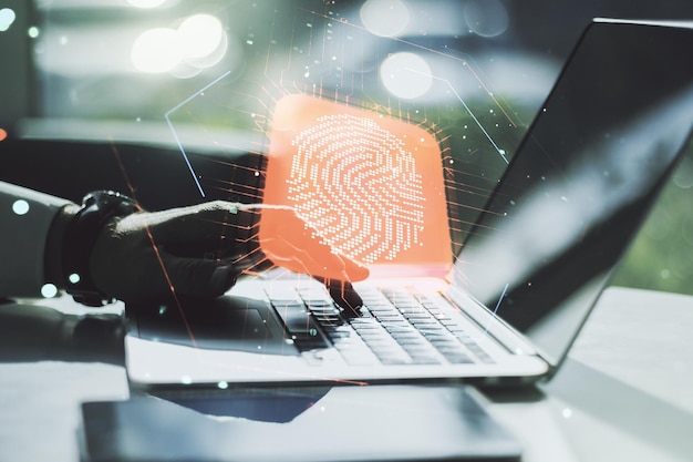 Multi exposure of abstract fingerprint scan interface with hands typing on computer keyboard on background digital access concept