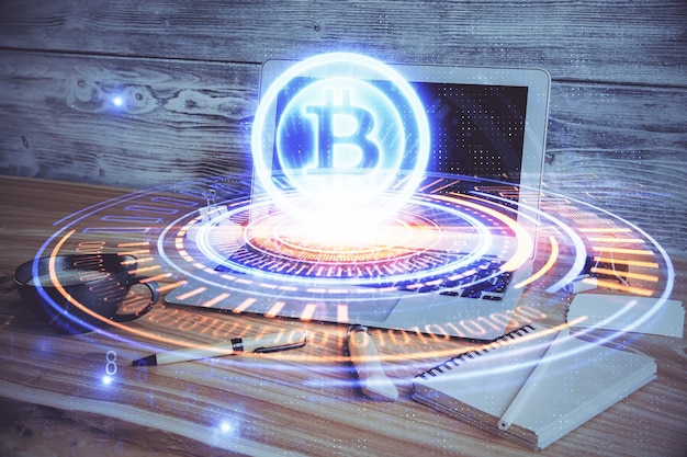 Multi exposure of blockchain and crypto economy theme hologram and table with computer background Concept of bitcoin cryptocurrency
