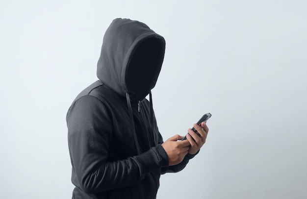 Mysterious man wearing hoodie and holding phone