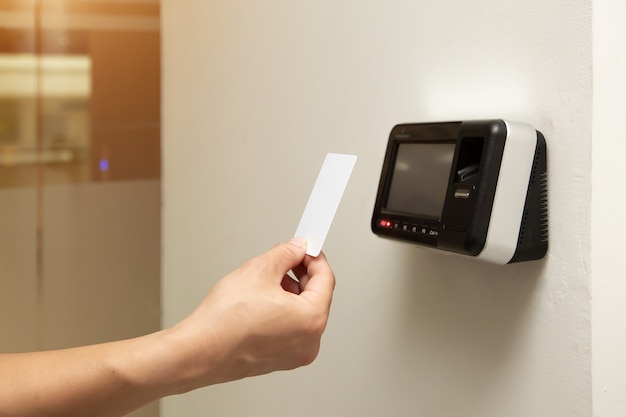 Office man using the id card to scan at the access control.