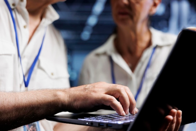 Old managers running analysis on server clusters helping businesses manage databases, host websites and store files. Knowledgeable computer scientists auditing high tech data center devices