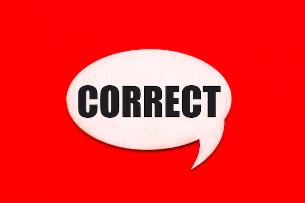 On a bright red background a light wooden curly card with the text CORRECT