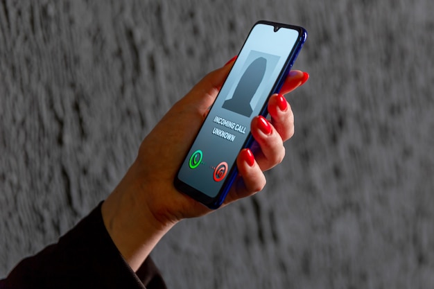 Phone call from unknown number. Scam, fraud or phishing with smartphone concept. Prank caller, scammer or stranger. Woman answering to incoming call. Hoax person with fake identity