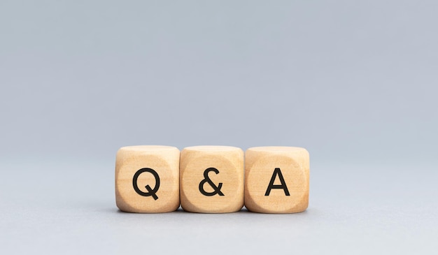 Q and A or questions and answers concept Text on Wooden cube blocks on gray background