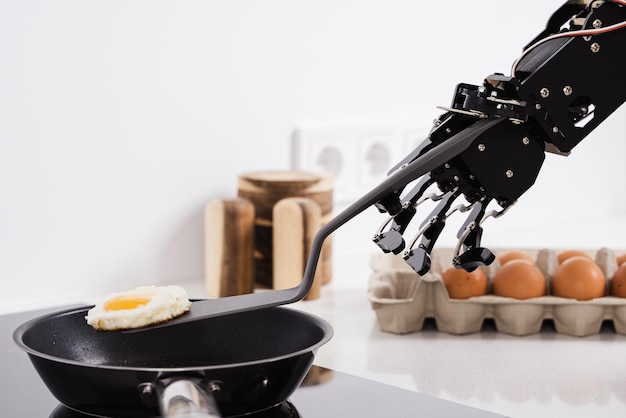 Real robot hand and frying pan with fried egg Concepts of AI development and robotic process automation