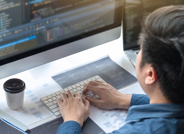 Rear view of man using laptop on table