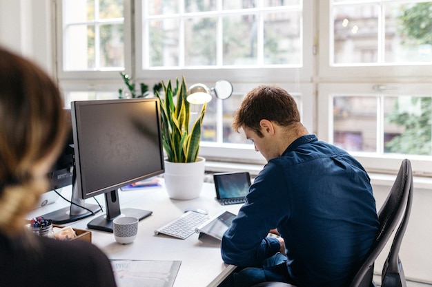 Rear view of man working at office