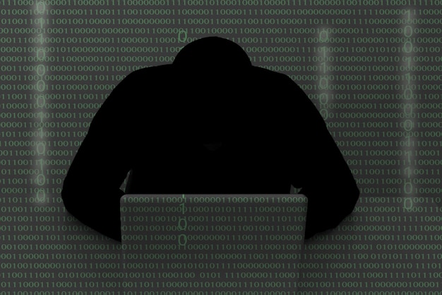 Rear view of silhouette man using mobile phone against wall