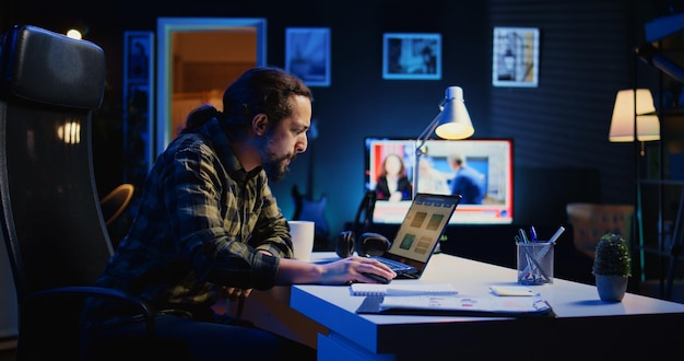 Remote worker using laptop to compare business revenue numbers
