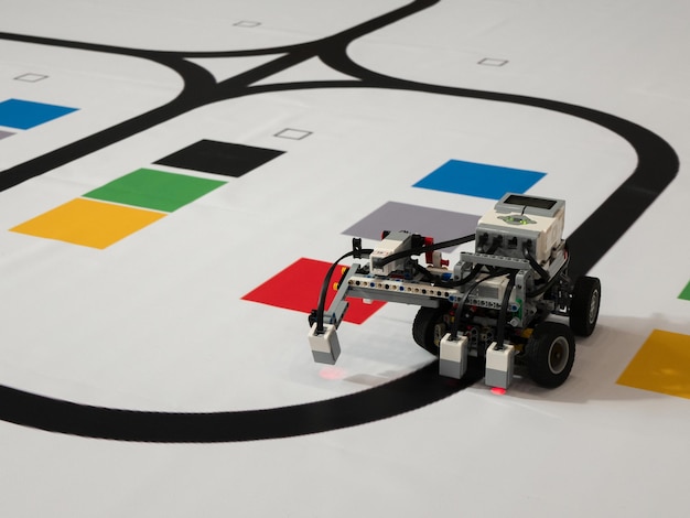 Robot with wheels is moving along the black line Line following with a sensor