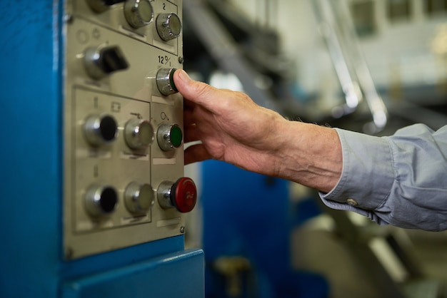 Senior Man Pushing Buttons on Control Panel