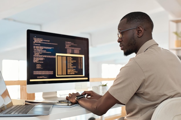 Seriøs programmør, der arbejder på måder at automatisere og frigive processer