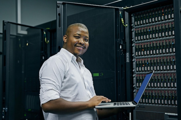 Server room black man or portrait of technician with laptop for online cyber security glitch or software IT support happy or friendly African engineer fixing network for information technology