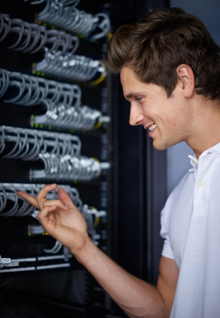 server room man and check cables with smile thinking and connectivity with hardware in night cybersecurity system it network and technician for glitch data center and problem solving for error