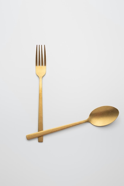 Set of golden metal cutlery on white background