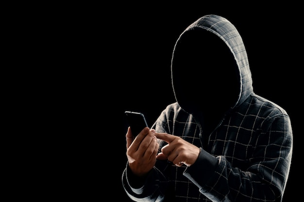 Silhouette of a man in a hood on a black background