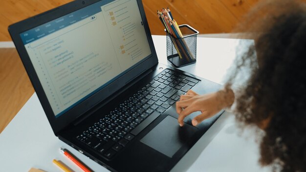 Smart african girl moving touch pad while use laptop programing code erudition
