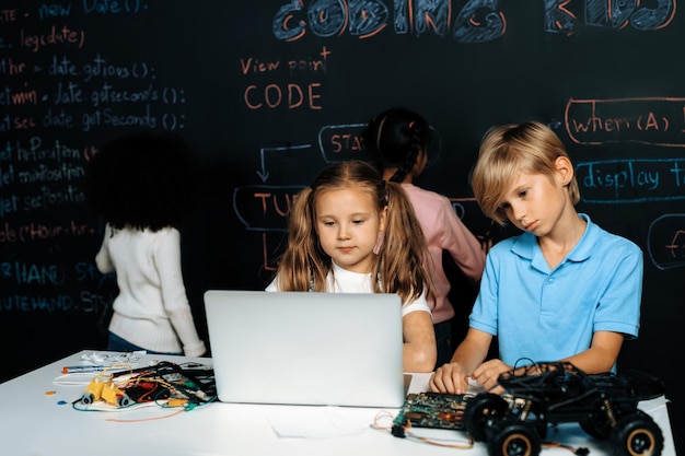 Smart girl in white bib learning robotics technology using laptop Erudition