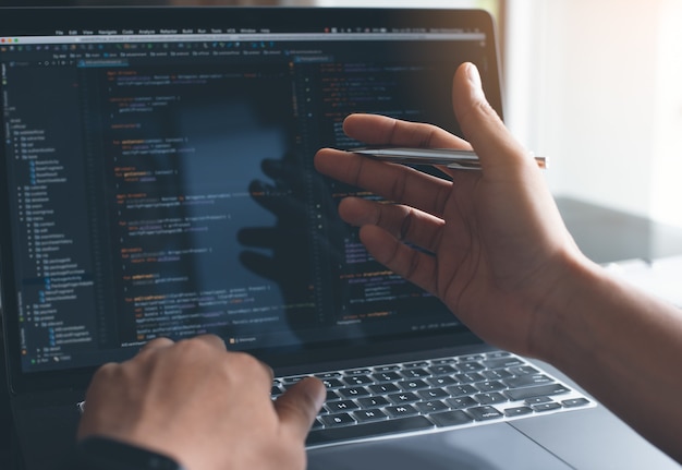 Software developer coding javascript on laptop computer