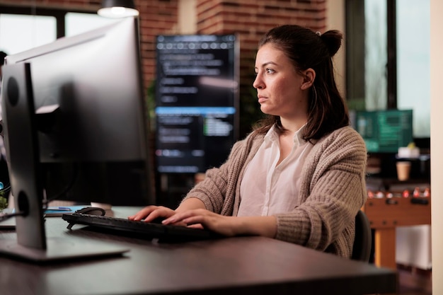 Software developer programming javascript code algorithm on computer, sitting at desk in it company office. Tech enginner working with html database script in cyber security agency.