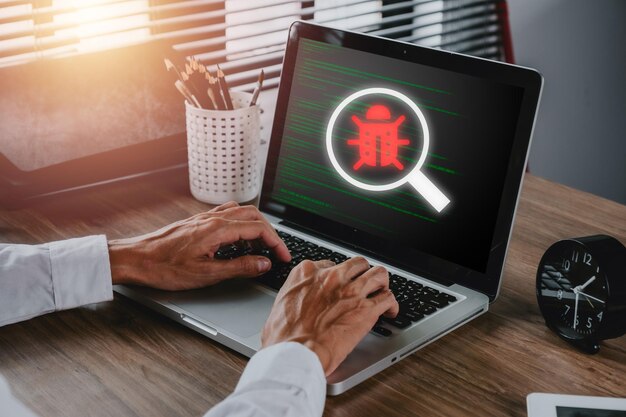 Software development and debugging concept Person hand using laptop computer with bug software icon on screen Software security Computer bug failure or error of software