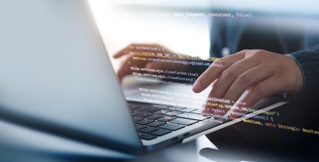 Software development concept Coding programmer software engineer working on laptop with javascript computer code on virtual screen internet of things IoT digital technology