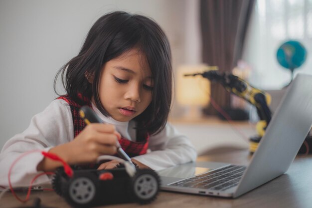stem education concept asian students learn at home by coding robot arms in stem mathematics engineering science technology computer code in robotics for kids concepts