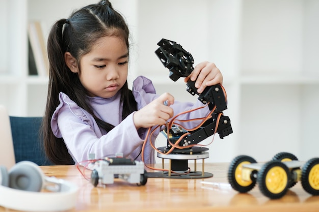 STEM education concept Asian young girl learning robot design