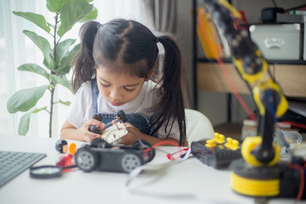 STEM education concept Asian young girl learning robot design