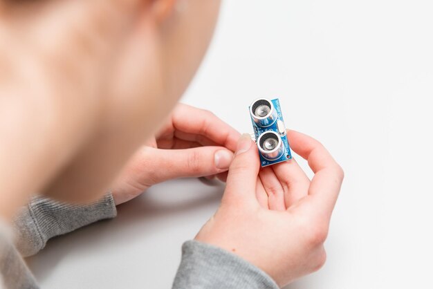 Student girl Learning To Program Robot Ultrasonic distance sensors facing Arduino nano board Stem projects and mini engineering projects building components