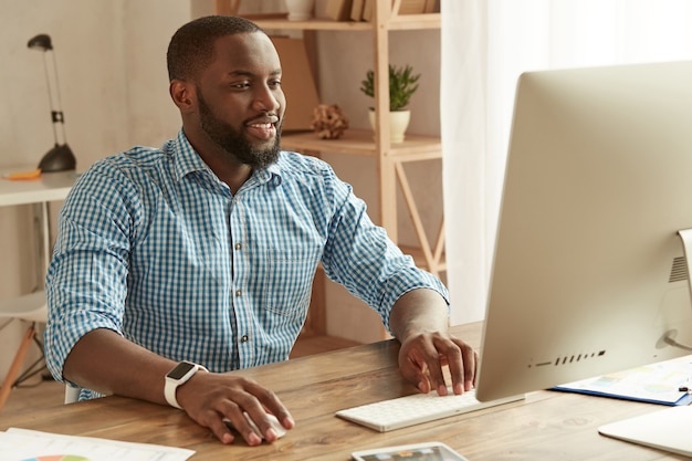 Successful businessman working remotely cheerful young afro american man in shirt working on the